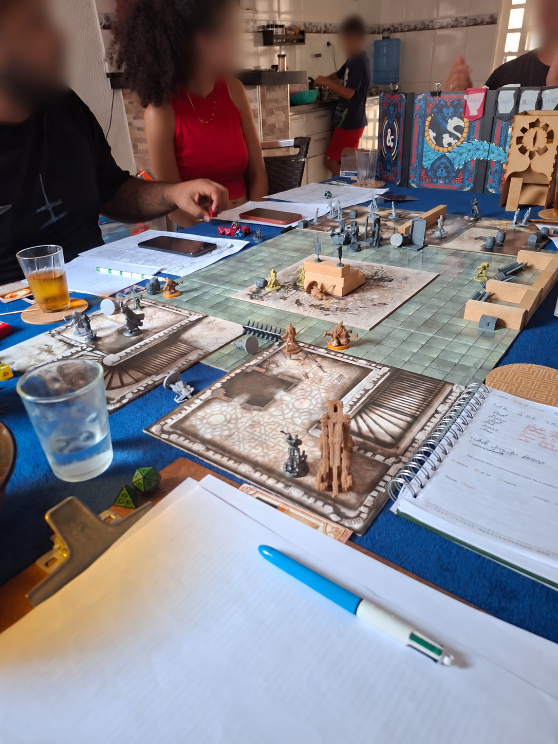 Uma sessão de RPG com jogadores, mapas e miniaturas sobre a mesa
