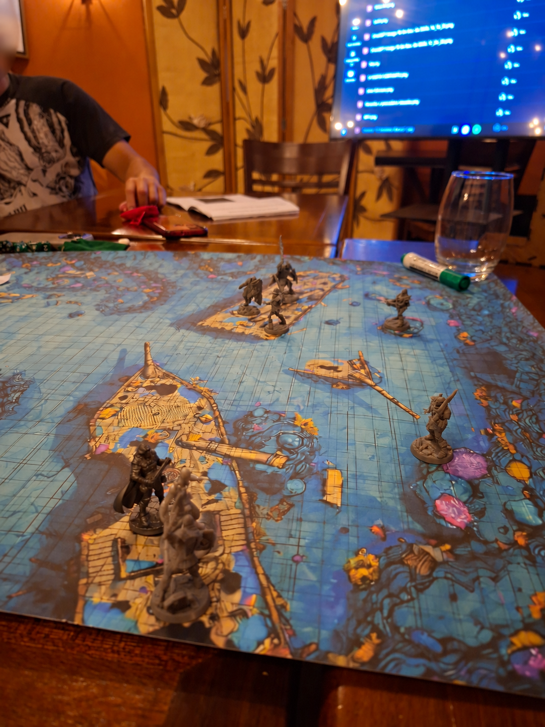 Miniaturas distribuídas sobre um mapa de cenário fantástico durante uma sessão